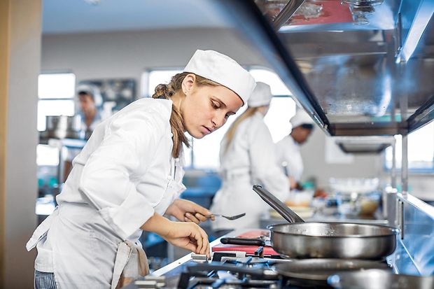 Teenage girl cooking in canteen kitchen